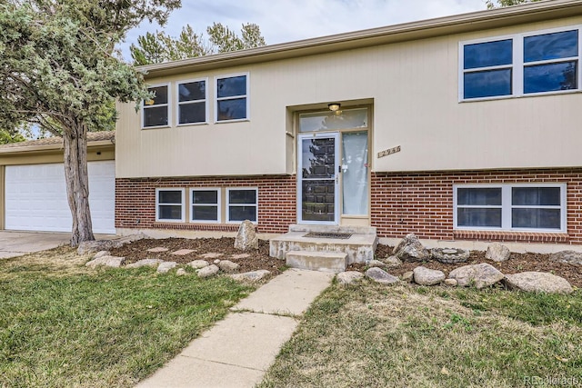 bi-level home featuring a garage and a front lawn