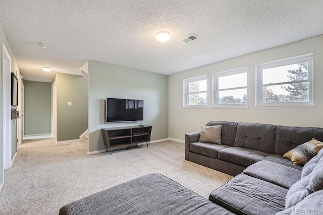 carpeted living room featuring a textured ceiling