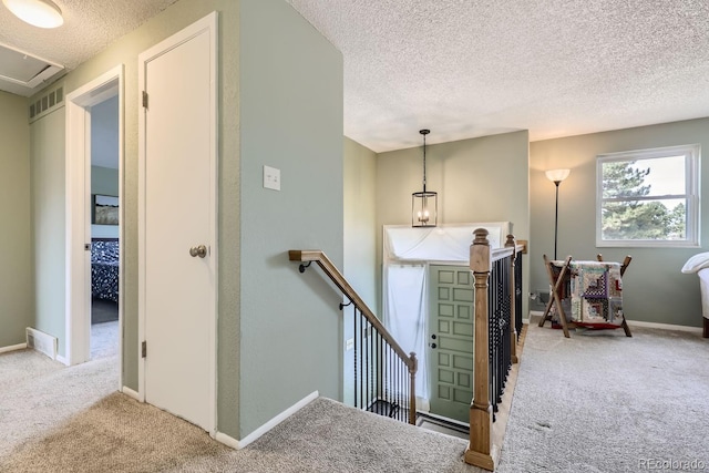 staircase with carpet floors and a textured ceiling