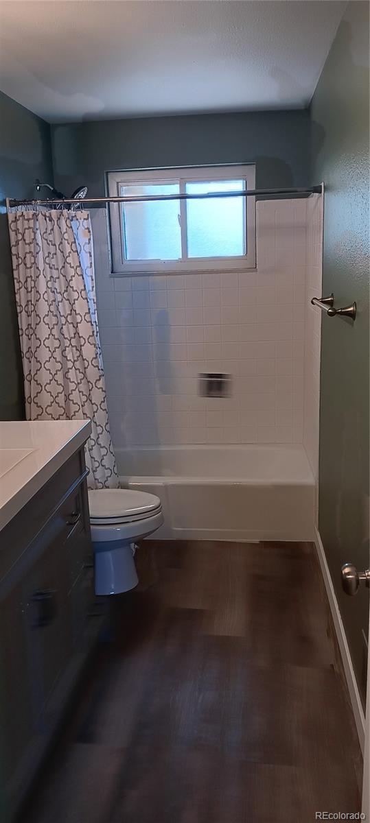 full bathroom with vanity, shower / bath combo with shower curtain, and toilet