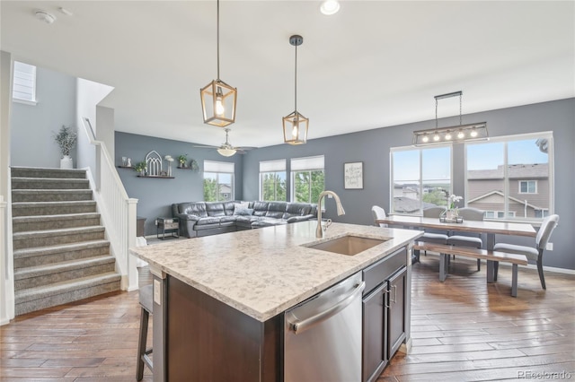 16226 W 94th Dr, Arvada, CO 80007 - kitchen featuring dishwasher, a sink, dark wood-style flooring, pendant lighting, and a center island with sink