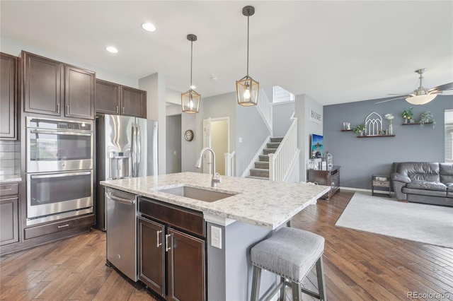 16226 W 94th Dr, Arvada, CO 80007 - kitchen featuring stainless steel appliances, a sink, open floor plan, a ceiling fan, and dark wood-style flooring