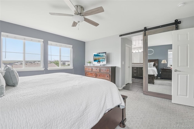 16226 W 94th Dr, Arvada, CO 80007 - bedroom with a barn door, ceiling fan, light colored carpet, and ensuite bathroom