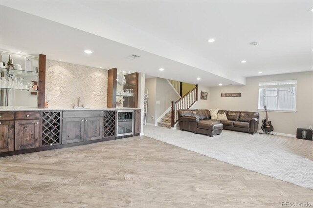 16226 W 94th Dr, Arvada, CO 80007 - living area featuring beverage cooler, wet bar, light wood finished floors, stairway, and recessed lighting