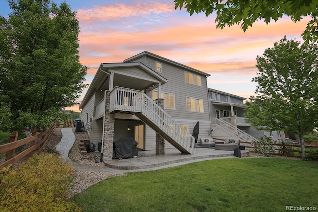 16226 W 94th Dr, Arvada, CO 80007 - back of property at dusk featuring stairway, a patio, and central air condition unit