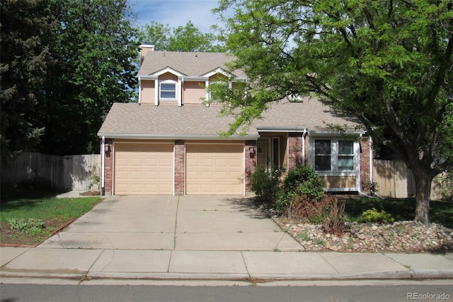 14503 E Wagon Trail Dr, Aurora, CO 80015 - view of property hidden behind natural elements with driveway, brick siding, a shingled roof, an attached garage, and a chimney