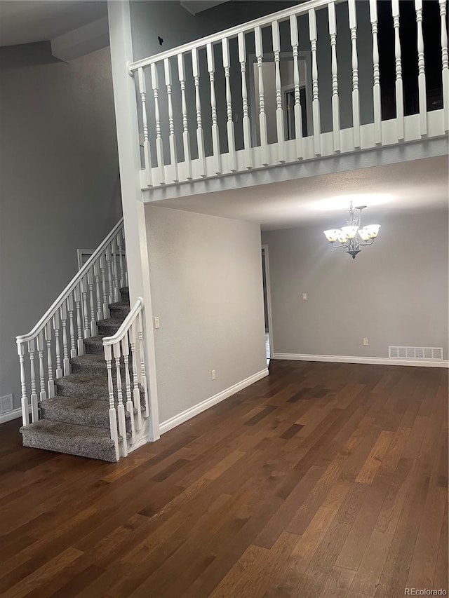 14503 E Wagon Trail Dr, Aurora, CO 80015 - unfurnished living room featuring wood finished floors, a chandelier, stairway, baseboards, and a high ceiling