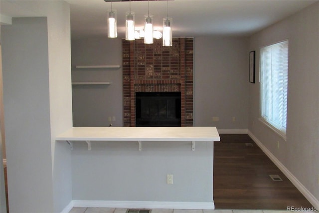 14503 E Wagon Trail Dr, Aurora, CO 80015 - unfurnished living room featuring a chandelier, baseboards, and a brick fireplace
