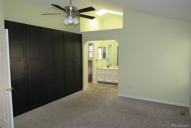 14503 E Wagon Trail Dr, Aurora, CO 80015 - unfurnished bedroom featuring carpet, a sink, ensuite bathroom, baseboards, and high vaulted ceiling
