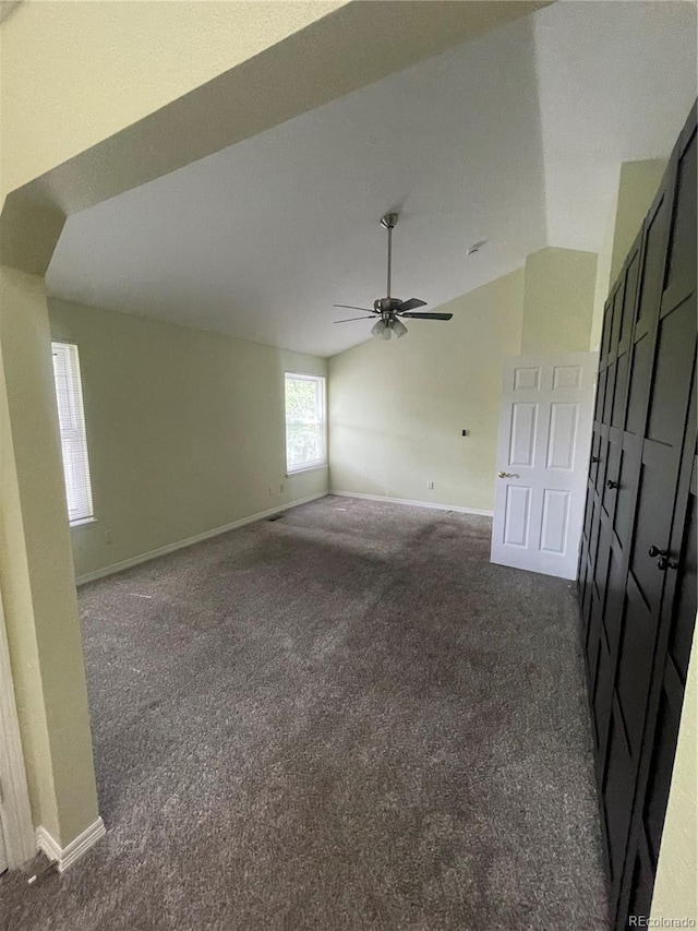 14503 E Wagon Trail Dr, Aurora, CO 80015 - spare room featuring dark carpet, lofted ceiling, baseboards, and ceiling fan
