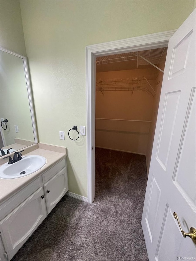 14503 E Wagon Trail Dr, Aurora, CO 80015 - bathroom with vanity, carpet, and a walk in closet