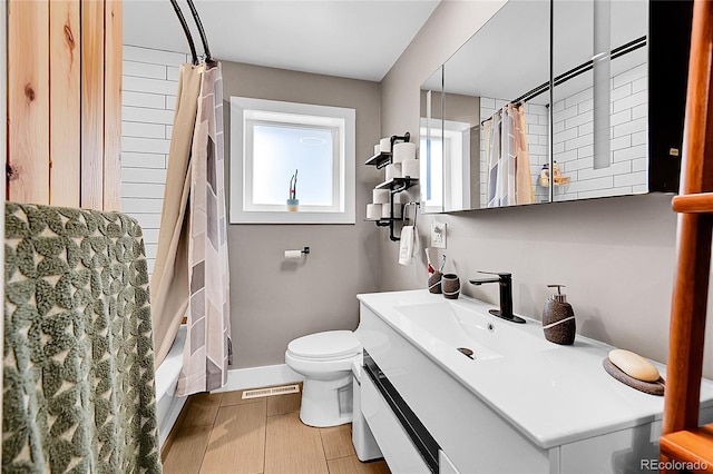 2201 Lima St, Aurora, CO 80010 - bathroom with toilet, baseboards, vanity, and visible vents