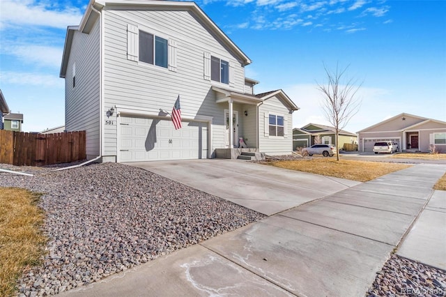 traditional-style home with driveway, a garage, and fence