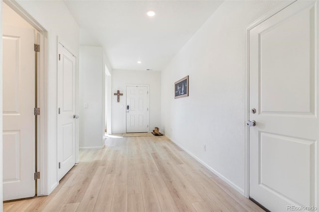 hall featuring baseboards, light wood finished floors, and recessed lighting