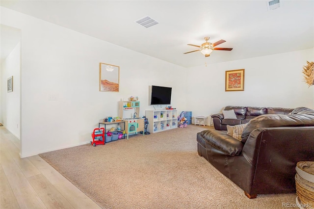 living area with light wood-style floors, visible vents, and a ceiling fan