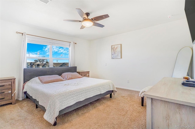 bedroom with visible vents, baseboards, a ceiling fan, and light colored carpet