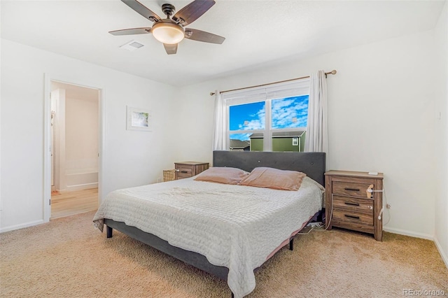 bedroom with baseboards, visible vents, connected bathroom, light colored carpet, and ceiling fan