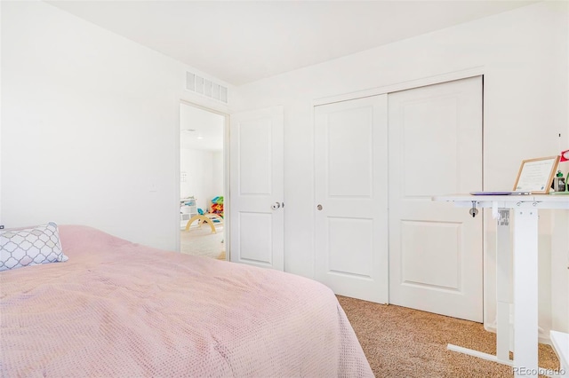 carpeted bedroom featuring a closet and visible vents