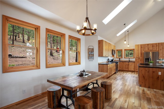 1321 Forest Edge Rd, Woodland Park, CO 80863 - dining room featuring a skylight, healthy amount of natural light, a chandelier, and high vaulted ceiling