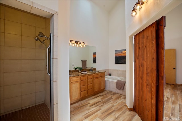 1321 Forest Edge Rd, Woodland Park, CO 80863 - full bathroom with wood finished floors, a bath, double vanity, a stall shower, and a high ceiling