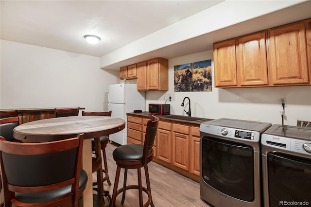 1321 Forest Edge Rd, Woodland Park, CO 80863 - kitchen with freestanding refrigerator, a sink, washer and dryer, black microwave, and dark countertops