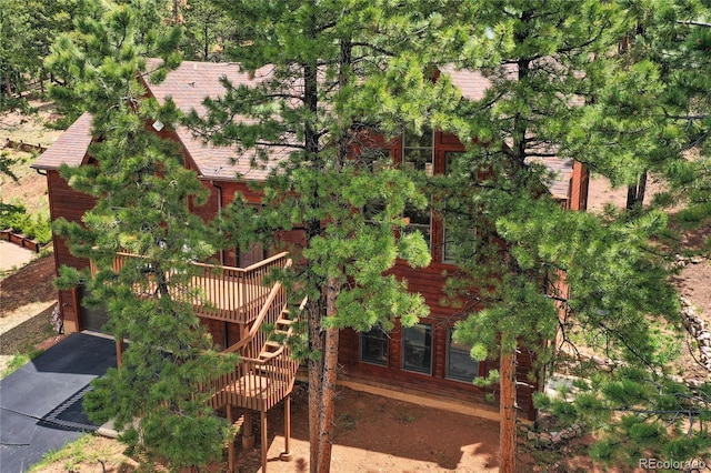 1321 Forest Edge Rd, Woodland Park, CO 80863 - rear view of property with asphalt driveway, a garage, a deck, and stairs