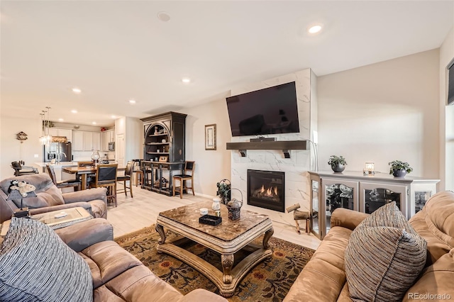 living room featuring light wood-type flooring and a premium fireplace