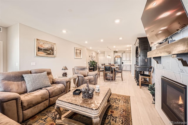 living room featuring light wood-type flooring and a tile fireplace