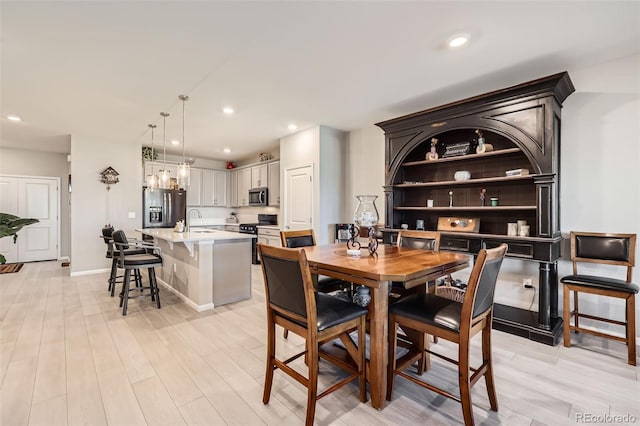 dining room with light hardwood / wood-style flooring and sink