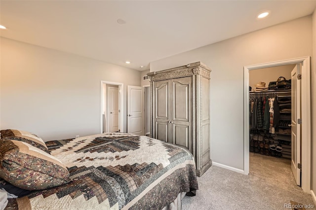 bedroom with a spacious closet, light carpet, and a closet