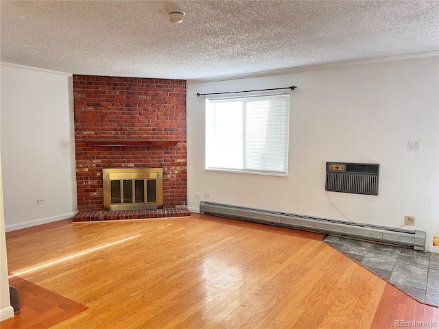 unfurnished living room with an AC wall unit, a fireplace, a textured ceiling, and a baseboard heating unit