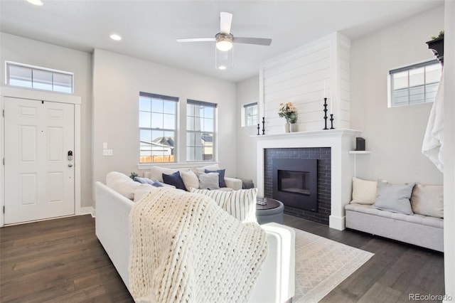 living room with ceiling fan, dark hardwood / wood-style floors, and a fireplace