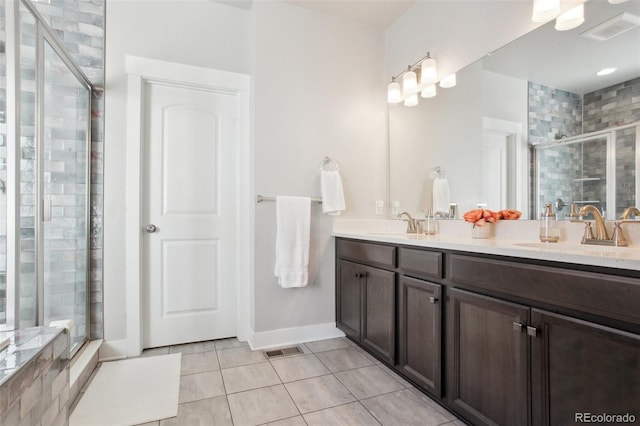 bathroom with vanity, a shower with shower door, and tile patterned floors