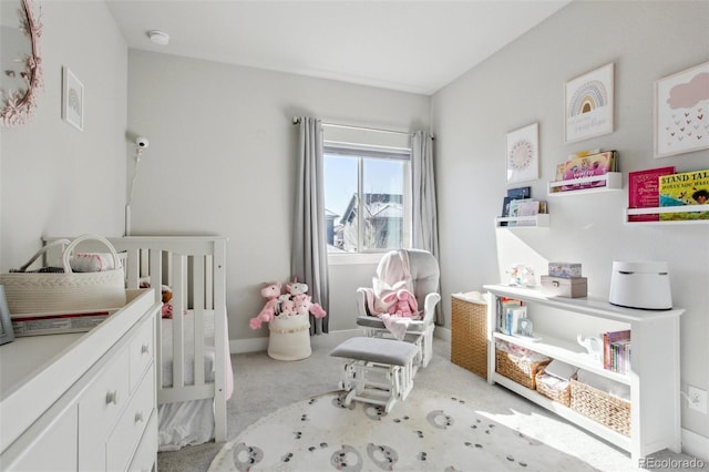 bedroom featuring a nursery area and light carpet