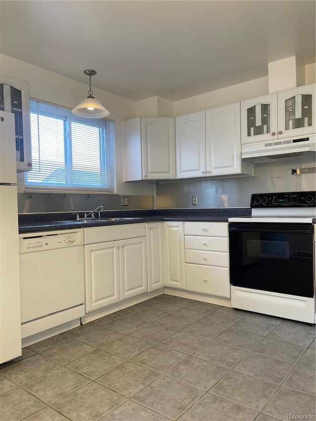 kitchen featuring pendant lighting, dark countertops, white cabinetry, white appliances, and under cabinet range hood