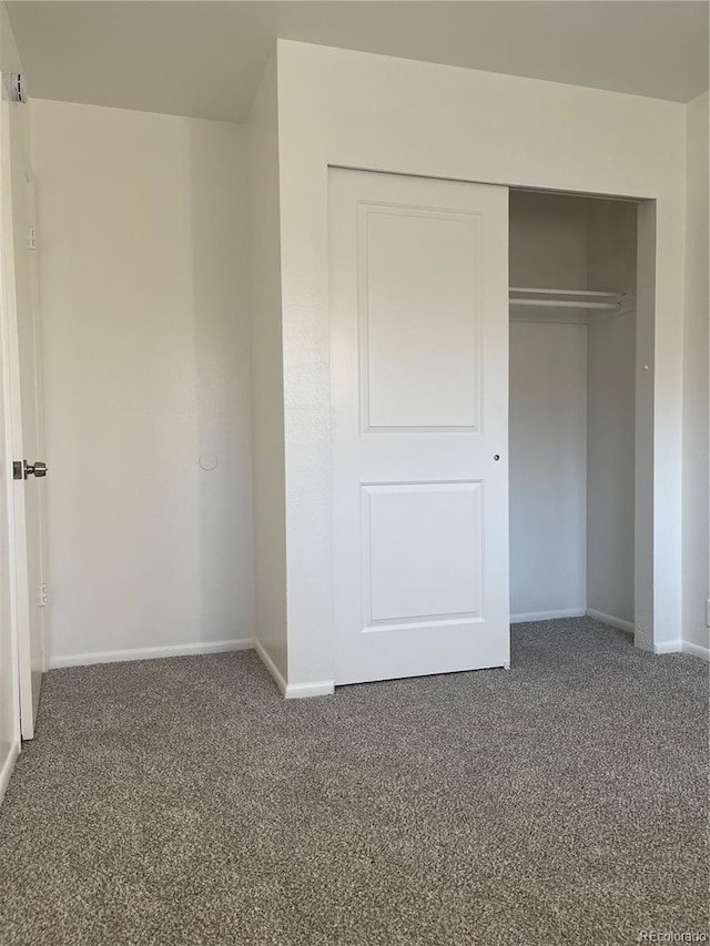 unfurnished bedroom featuring a closet, carpet flooring, and baseboards