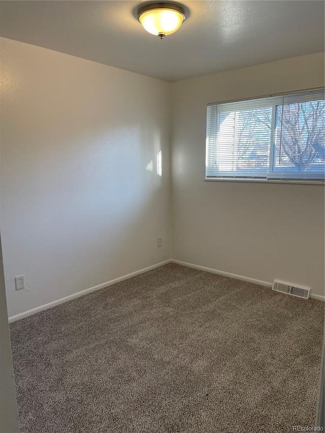 unfurnished room with baseboards, visible vents, and carpet flooring