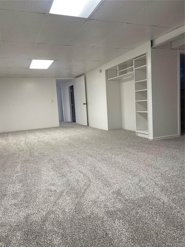 unfurnished bedroom with a paneled ceiling, a closet, and carpet flooring