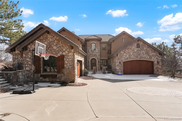 651 Ruby Trust Dr, Castle Rock, CO 80108 - view of front of home featuring stone siding, curved driveway, stucco siding, an attached garage, and a tile roof