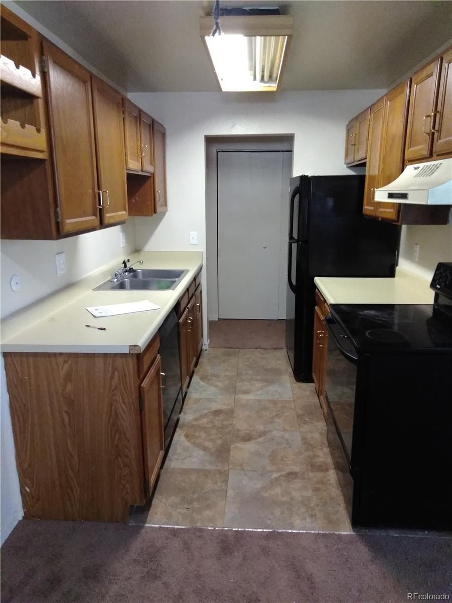 kitchen featuring sink, light tile floors, and black appliances