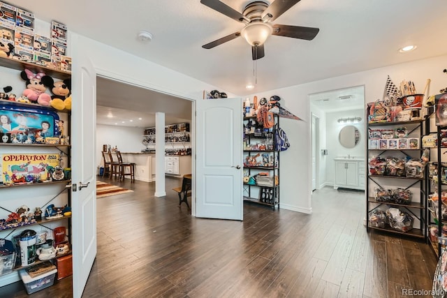 interior space featuring dark wood-type flooring, ceiling fan, and decorative columns