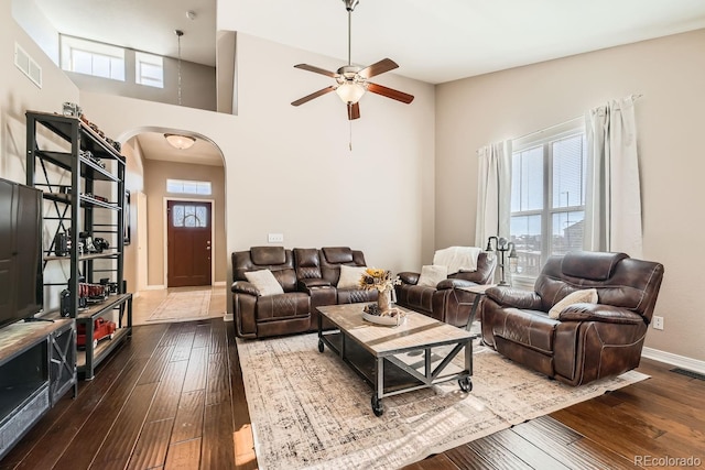 living room featuring hardwood / wood-style floors, a high ceiling, and ceiling fan