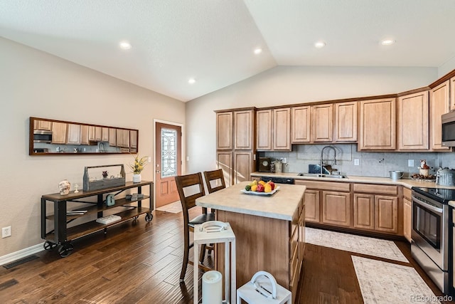 kitchen with stainless steel appliances, sink, dark hardwood / wood-style floors, lofted ceiling, and a center island