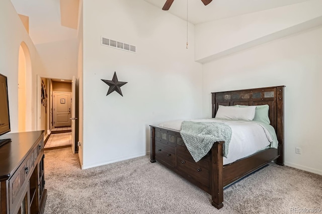 bedroom with ceiling fan, light carpet, and high vaulted ceiling