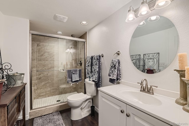 bathroom featuring toilet, vanity, hardwood / wood-style flooring, and walk in shower