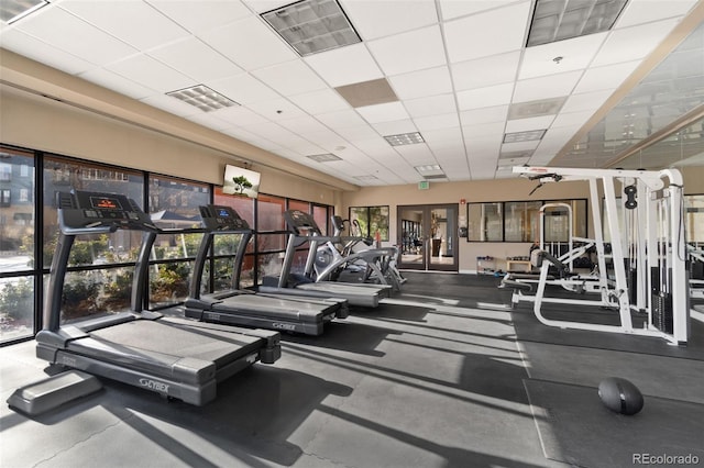 exercise room with a paneled ceiling and plenty of natural light