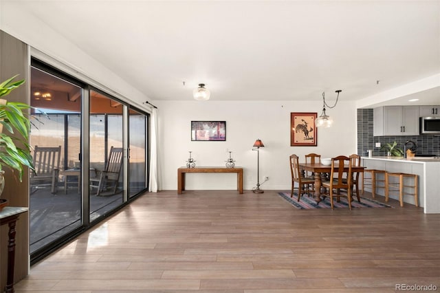 dining space with sink and hardwood / wood-style floors