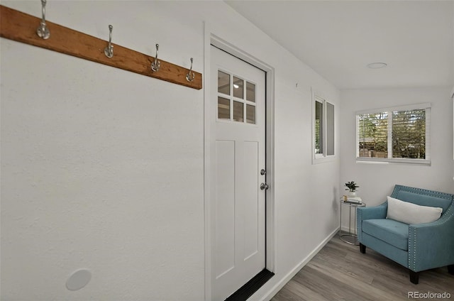 doorway to outside featuring wood finished floors and baseboards