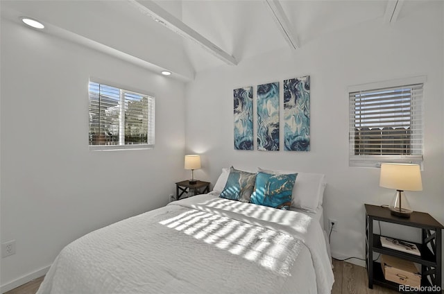 bedroom with wood finished floors and lofted ceiling