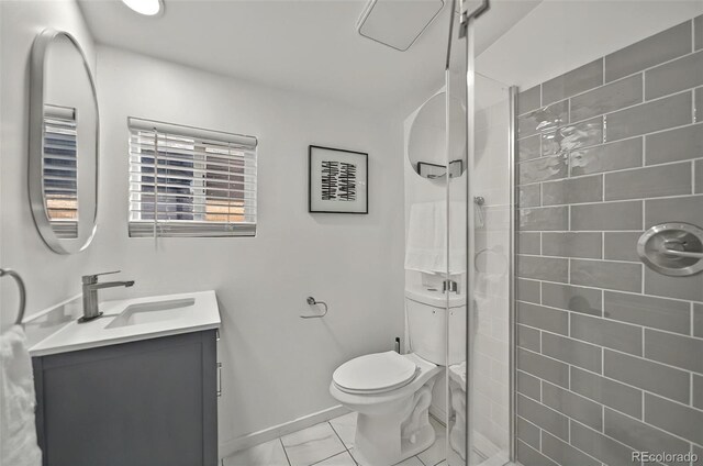 bathroom with vanity, a shower stall, toilet, marble look tile flooring, and baseboards